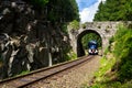 Ceske drahy CD railway carrier company train passes under romantic stone bridge in beautiful forest in Ore Mountains Royalty Free Stock Photo