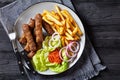 Cevapcici with potato fries, lettuce, onion, ajvar Royalty Free Stock Photo