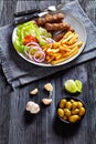 Cevapcici with potato fries, lettuce, onion, ajvar Royalty Free Stock Photo