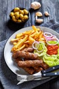 Cevapcici with potato fries, lettuce, onion, ajvar Royalty Free Stock Photo