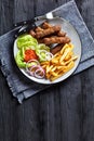 Cevapcici with potato fries, lettuce, onion, ajvar Royalty Free Stock Photo