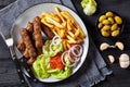 Cevapcici with potato fries, lettuce, onion, ajvar Royalty Free Stock Photo