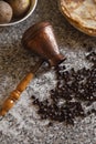 Cezve with spilled coffee beans and pancakes with boiled potatoes in the background Royalty Free Stock Photo