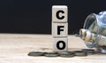 CFO on cubes on the background of a capacity with money