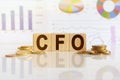 CFO the word on wooden cubes, cubes stand on a reflective surface, in the background is a business diagram Royalty Free Stock Photo