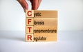 CFTR medical concept. Wooden cubes and blocks with the inscription `CFTR - cystic fibrosis transmembrane regulator`, male hand. Royalty Free Stock Photo