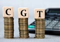 CGT - acronym on wooden cubes on the background of coins and calculator