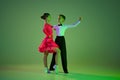 Cha cha cha, rumba, tango. Carming little boy and beautiful girl dancing ballroom dance isolated over green background Royalty Free Stock Photo