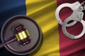 Chad flag with judge mallet and handcuffs in dark room. Concept of criminal and punishment, background for judgement Royalty Free Stock Photo