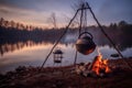 chai tea kettle hanging from a tripod over a crackling campfire