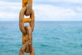 Chain and blue sea. Yellow mooring chain of cargo ship. Commercial shipment by sea.