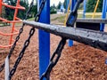 A chain climbing net on a bright, colorful playground on a rainy day