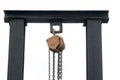Chain and crane with black iron pole against white background.