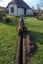 chain excavator while working in the green belt, visibly sky, grass, house excavation