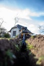 chain excavator while working in the green belt, visibly sky, grass, house excavation