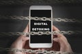 Chain fence locking hands holding a mobile phone with Digital Detoxing text