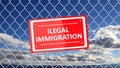 Chain fence with red sign Illegal Immigration