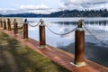 Chain fence safety barrier on edge of Lake Washington in Luther Burbank Park on Mercer Island, WA, rusty iron posts with metal han