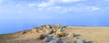 A chain of granite stones on the shore of the bay. Early summer morning. Bright blue sky and cirrus clouds Royalty Free Stock Photo