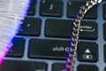 Chain on laptop computer keyboard, glowing optical fibres