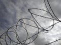 Background. Barbed wire under twilight cloudy gray sky. Chain link fence