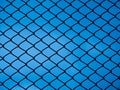 Chain link fence on blue background Royalty Free Stock Photo