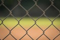 A chain link fence with a blurred background of a baseball field. Royalty Free Stock Photo