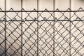 Chain link fence casting shadow on white wall