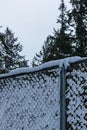 Chain link fence covered in fluffy white snow Royalty Free Stock Photo