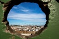 chain-link fence with hole against a skyline