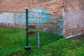 Chain link fence whit padlock. There is a dirty brick wall behind the fence Royalty Free Stock Photo