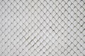 Chain Link fence on white cement wall background Royalty Free Stock Photo