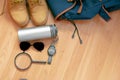 Some baggage to a trip, top view of a backpack, sunglasses, a watch, magnifying glass, boots and a thermos Royalty Free Stock Photo