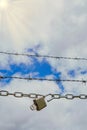 chain with padlock open with key next to a barbed wire Royalty Free Stock Photo