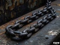 A chain is sitting on top of a rusted metal bench Royalty Free Stock Photo