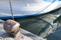 Chain tied on a bollard. Mooring rope wrapped around the cleat on sea background. Metal capstan in harbor for the mooring of yacht