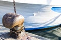 Chain tied on a bollard. Mooring rope wrapped around the cleat on sea background. Metal capstan in harbor for the mooring of yacht