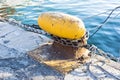 Chain tied on a bollard. Mooring rope wrapped around the cleat on sea background. Metal capstan in harbor for the mooring of yacht