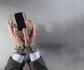 Chain tied businessman hands grabbing corporate communication phone