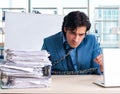 Chained male employee unhappy with excessive work Royalty Free Stock Photo