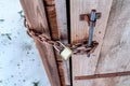 Chained outdoor wooden bathroom door with long shackle combination padlock Royalty Free Stock Photo