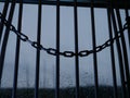 Chains hang on prison bars against window