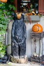 Chainsaw carved wood bear with a fall pumpkin and autumn decorations