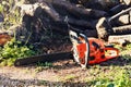 Chainsaw in front of a pile of wood logs Royalty Free Stock Photo