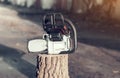 Chainsaw on a stump on the street background Royalty Free Stock Photo