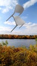 Chair in the air, river, autumn landscape, blue sky with clouds, bright rainbow colors of nature Royalty Free Stock Photo