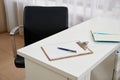 Chair and blank clipboard and pen on a table in office Royalty Free Stock Photo