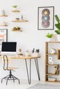 Chair at desk with desktop computer in bright workspace interior