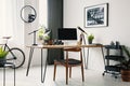 Chair at desk with desktop computer in home office interior with