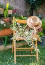 Chair in the garden Hat, basket with olive brunches, warm sunny day Royalty Free Stock Photo